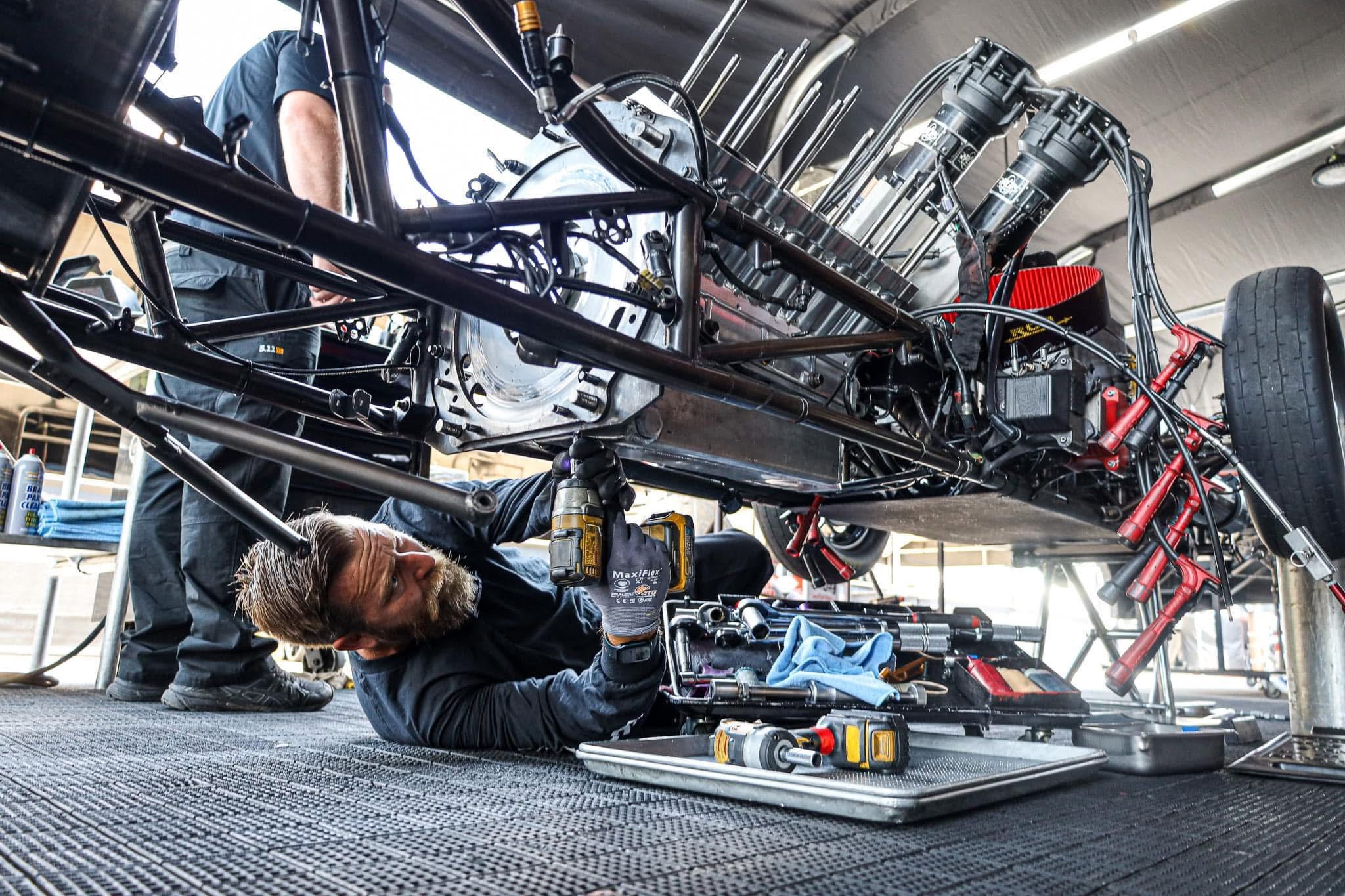 Matthew working beneath a race car